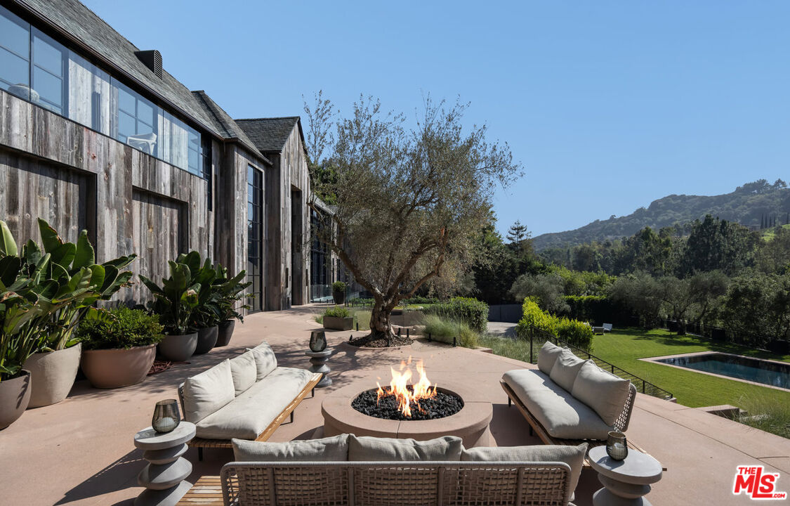 a view of a patio with couches table and chairs and potted plants