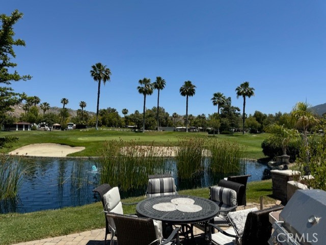 a view of a lake with couches chairs and a yard