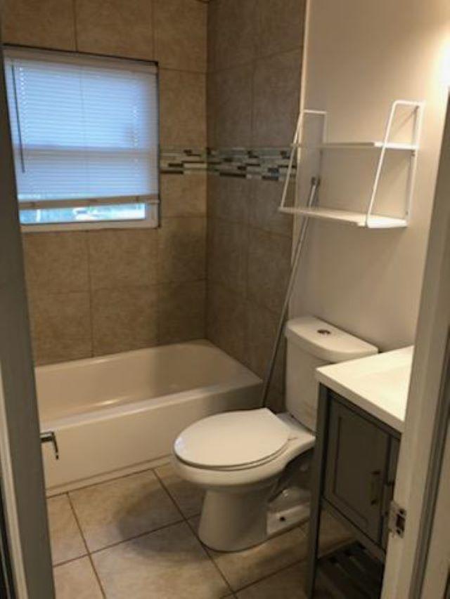 a white toilet sitting next to a bath tub