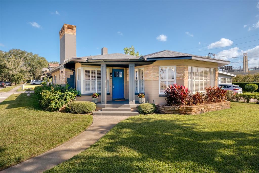 a front view of a house with a yard and potted plants