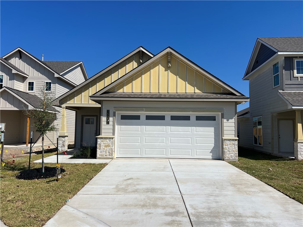 Craftsman house featuring a front lawn and a garag