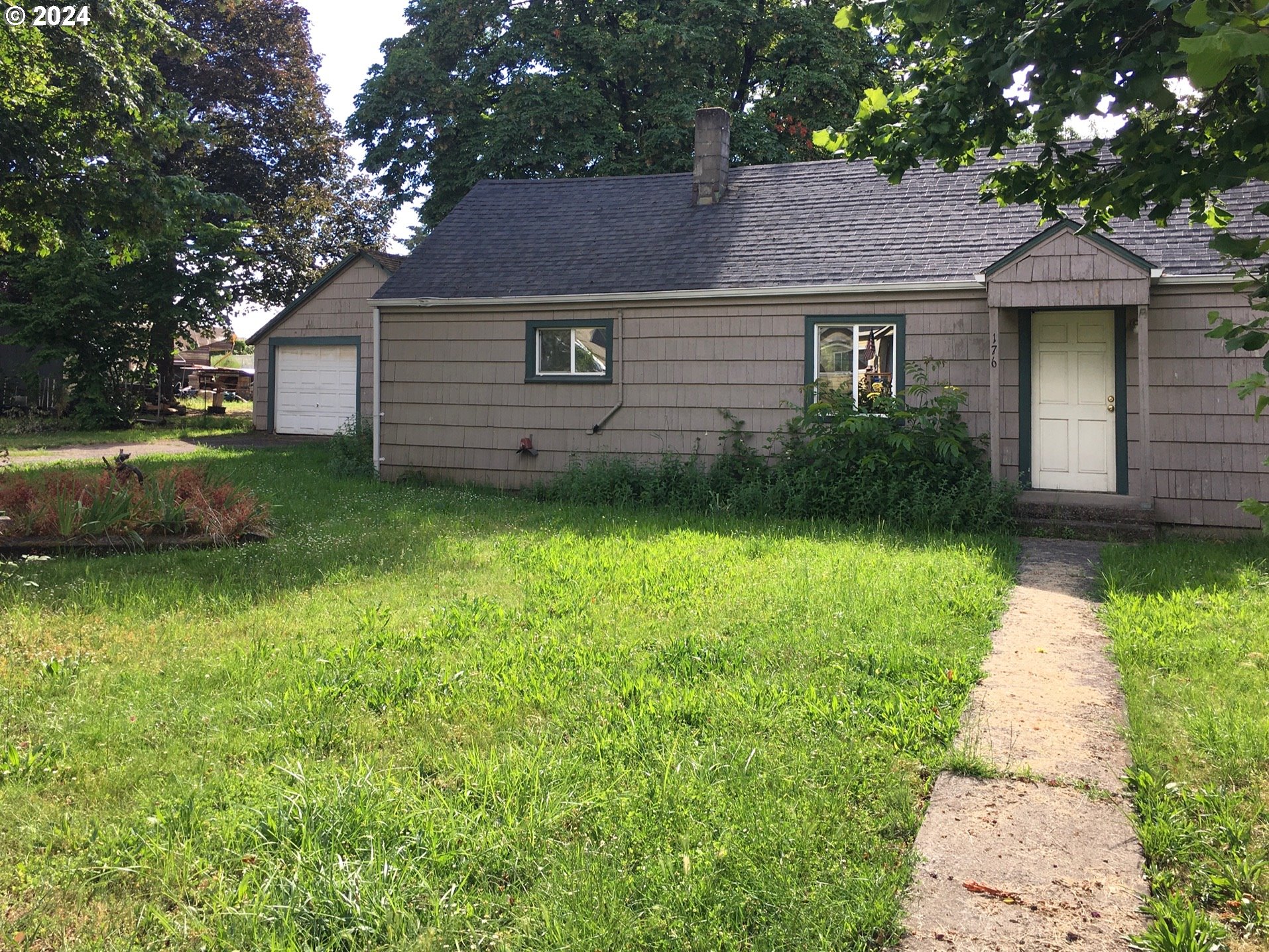 a front view of a house with a garden and yard