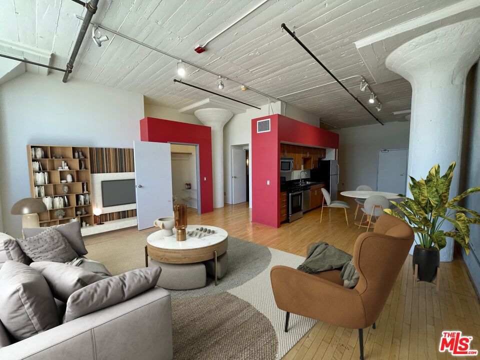 a living room with furniture and a dining table with wooden floor