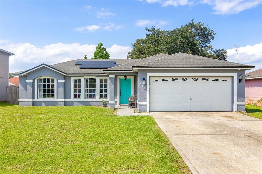 a front view of a house with a yard and garage