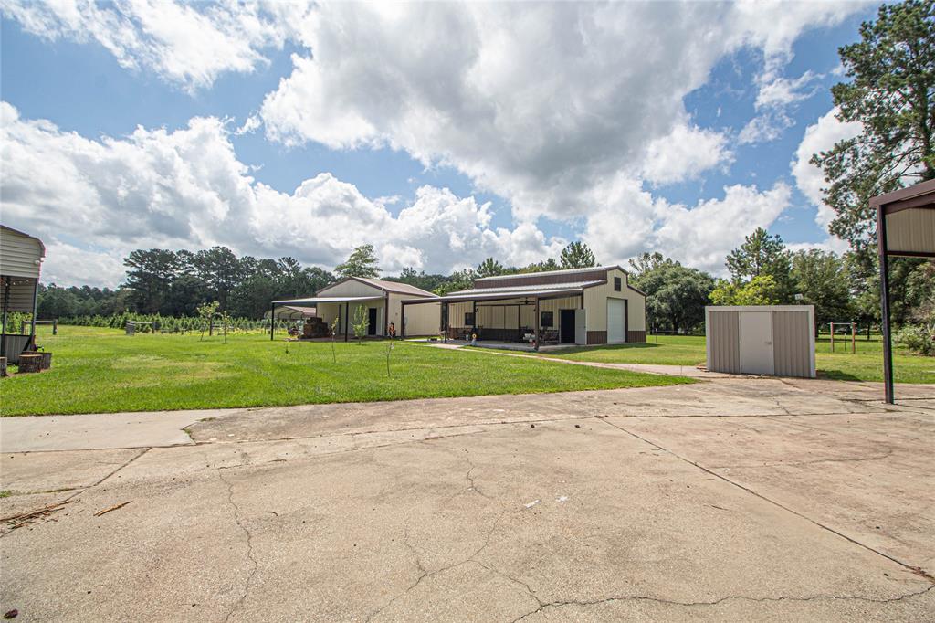 a view of a house with a big yard and a large trees