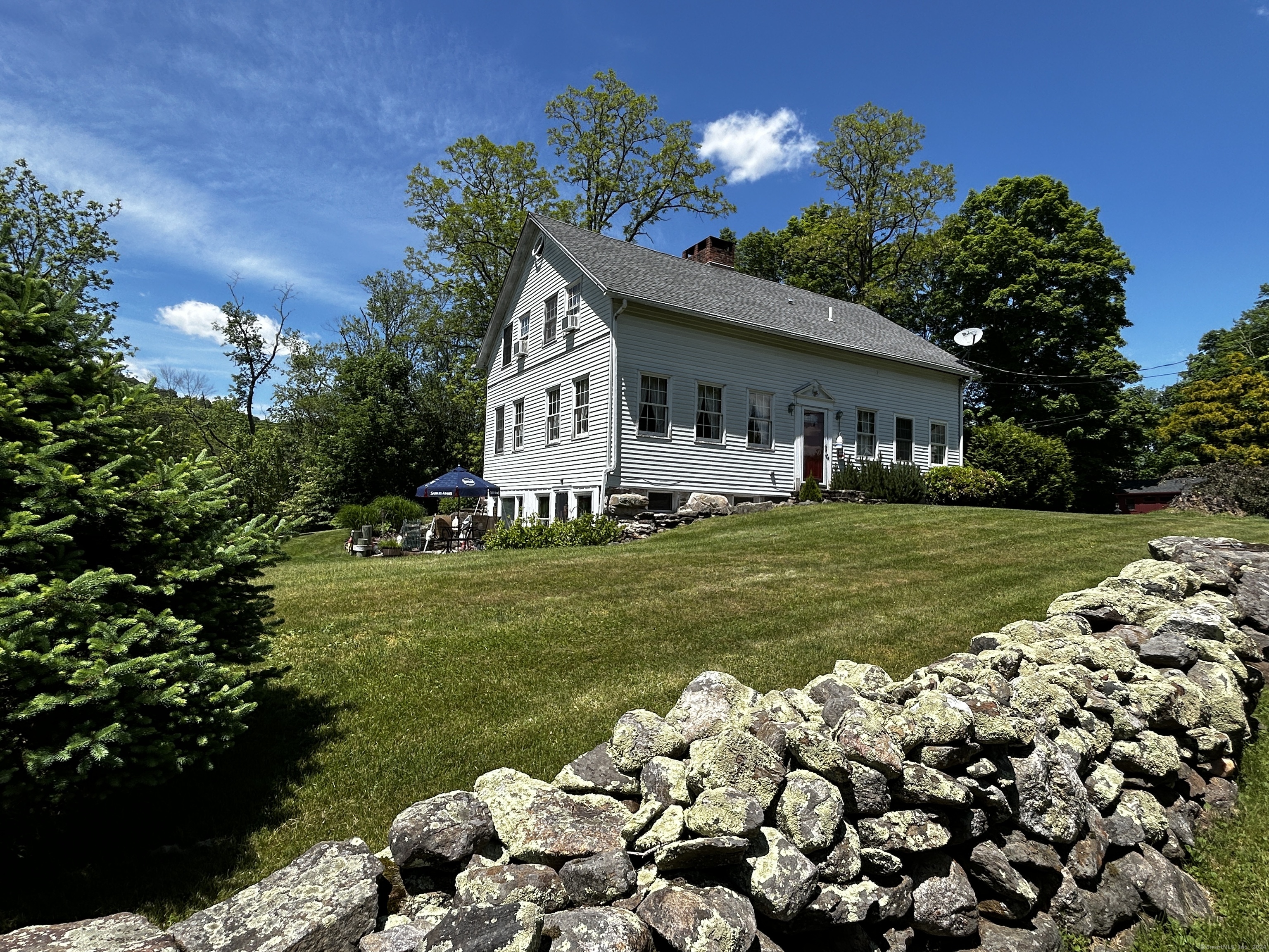 a front view of a house with a big yard and a garden