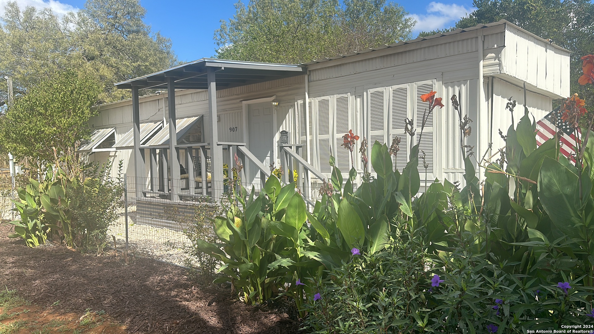 a view of a house with a small yard and wooden fence