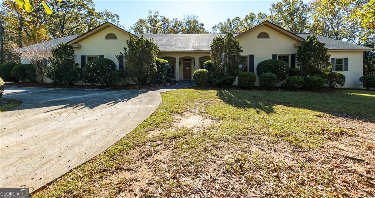 a view of house with yard and tree in front of it