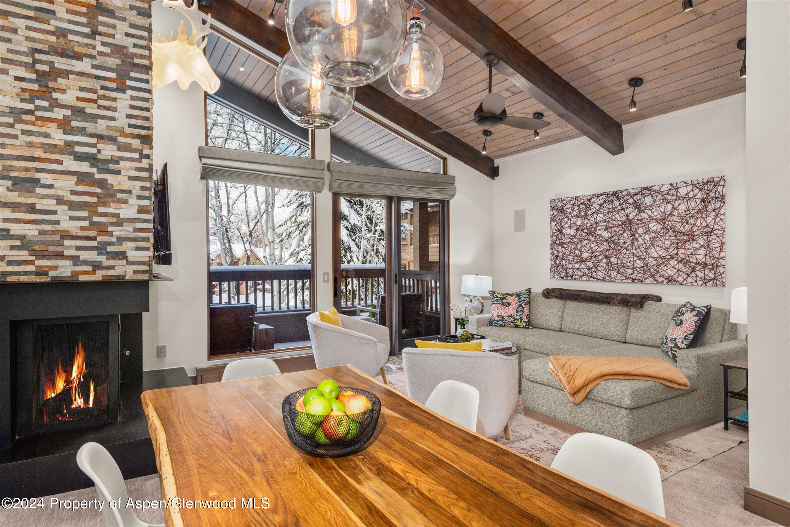 a living room with furniture a fireplace and a floor to ceiling window