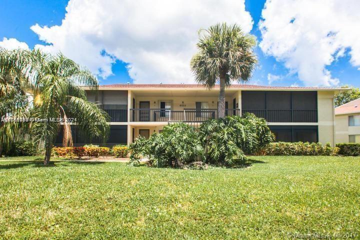 a front view of house with yard and trees around