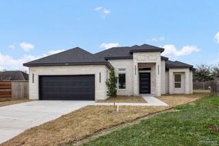 View of front of house featuring a front lawn and a garage