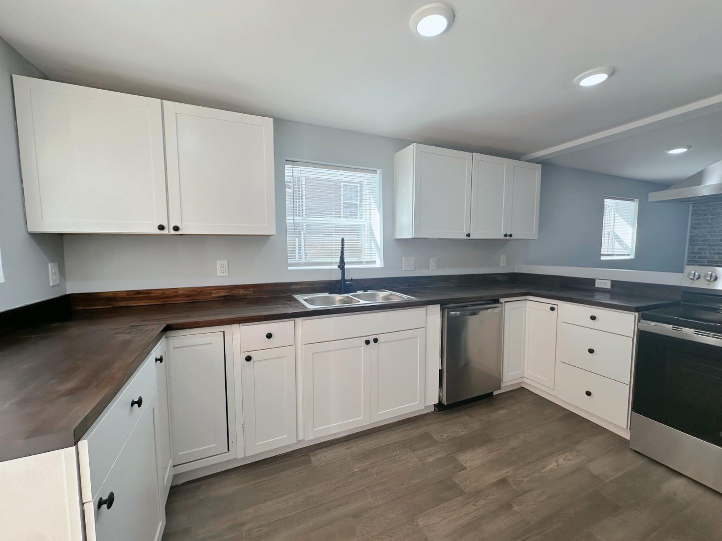 a kitchen with granite countertop white cabinets sink and dishwasher