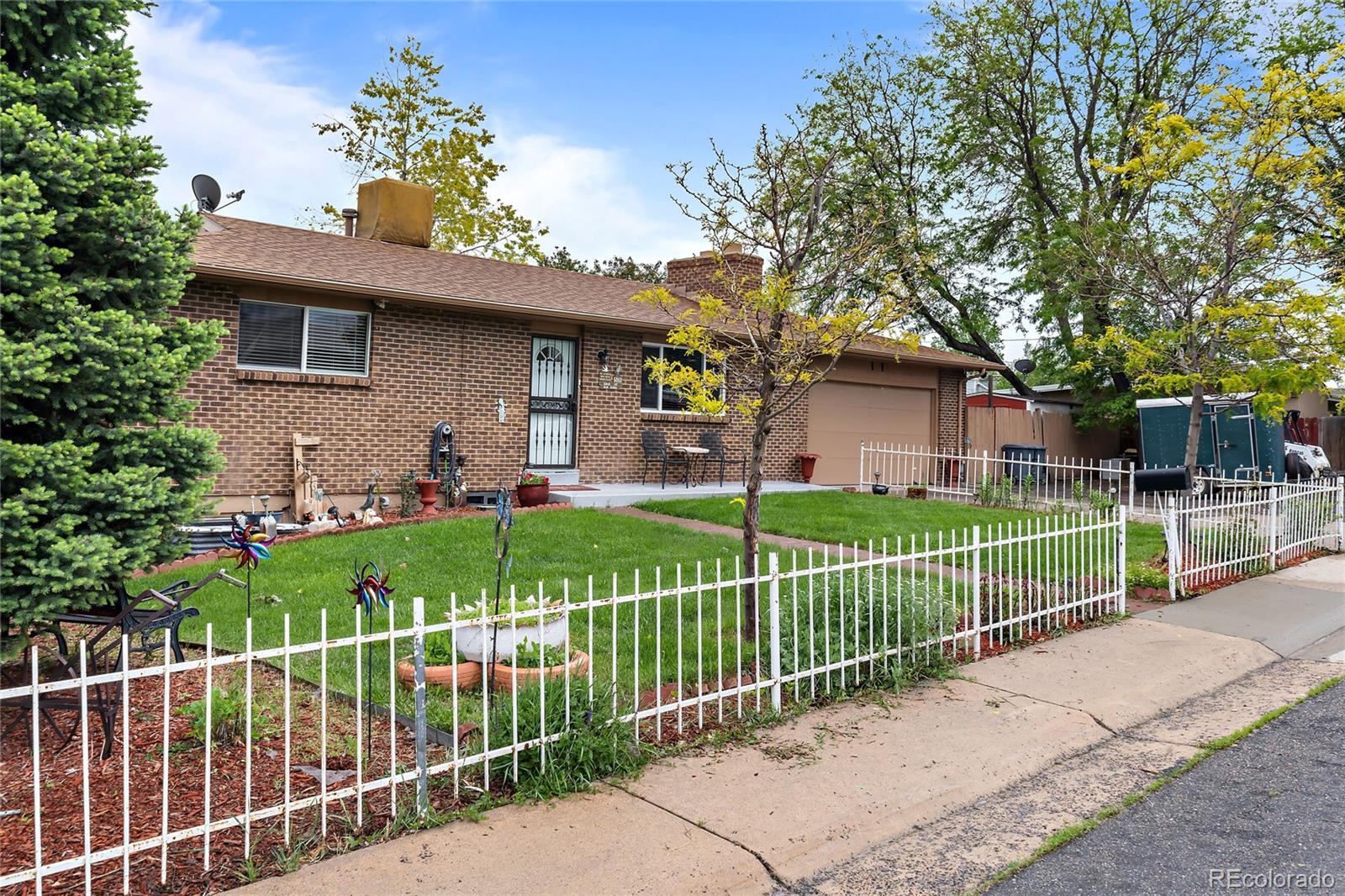 a view of a house with a fence and a tree