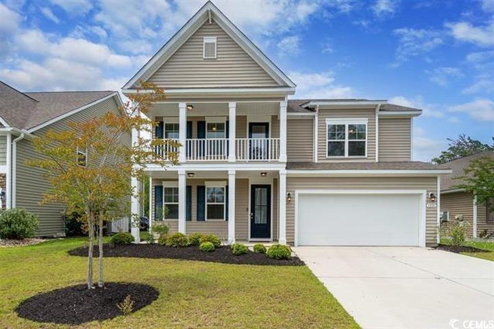 View of front facade with a garage, a balcony, and