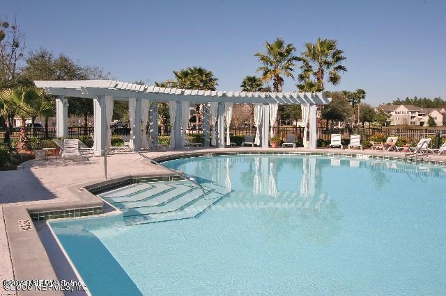 a view of a house with swimming pool next to a yard