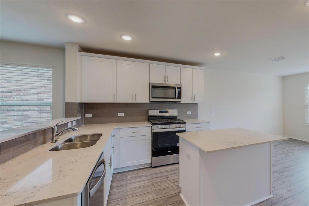 a kitchen that has a sink and a stove in it