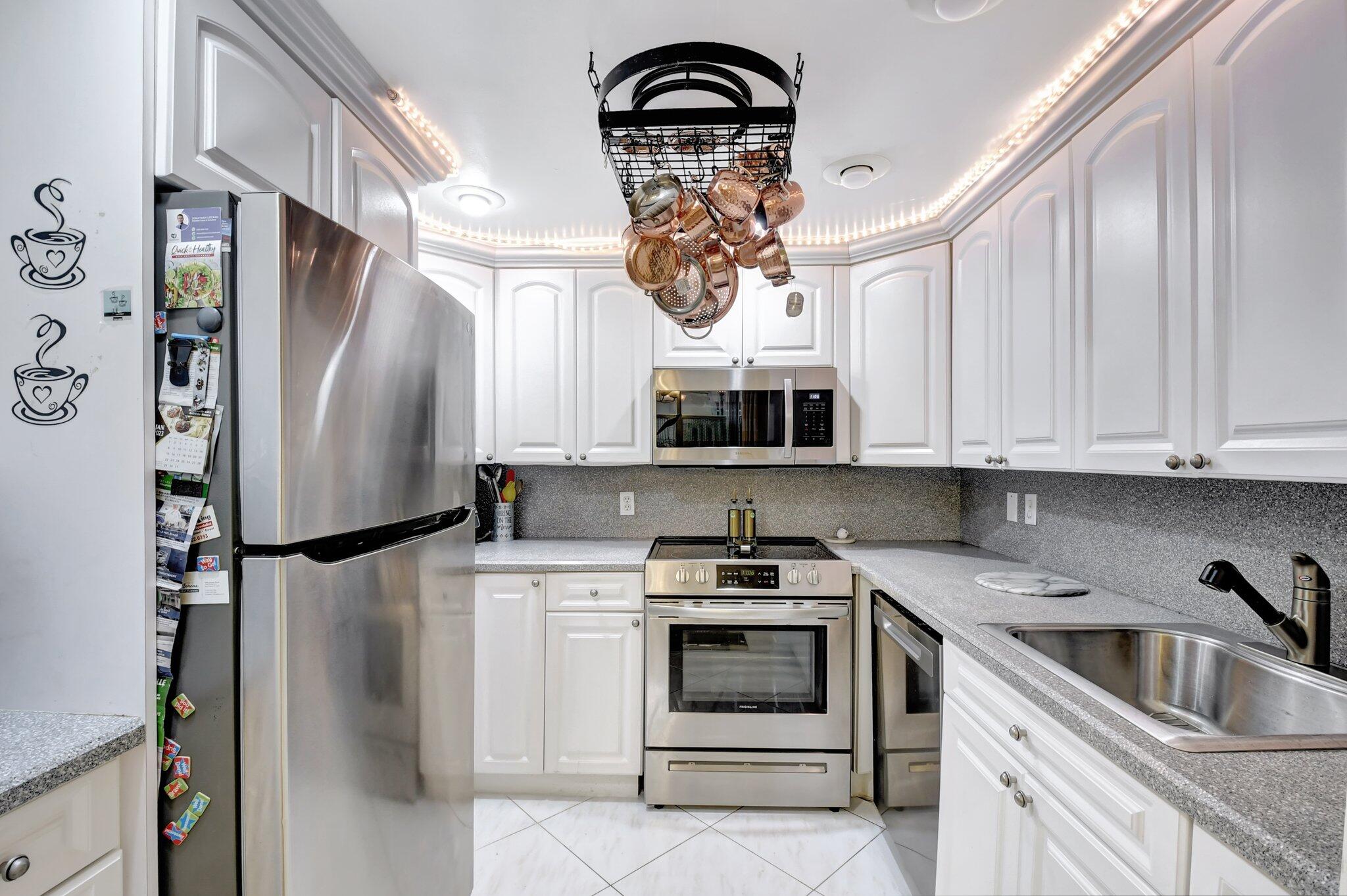 a kitchen with stainless steel appliances granite countertop a refrigerator sink and stove