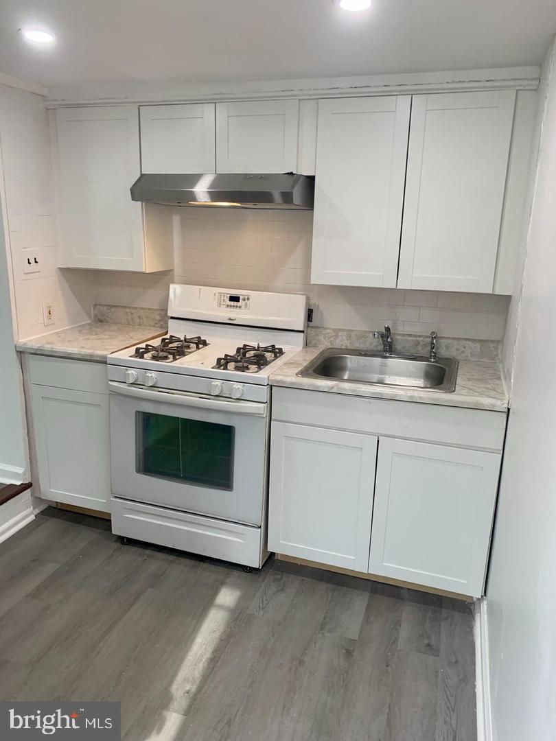 a white stove top oven sitting inside of a kitchen