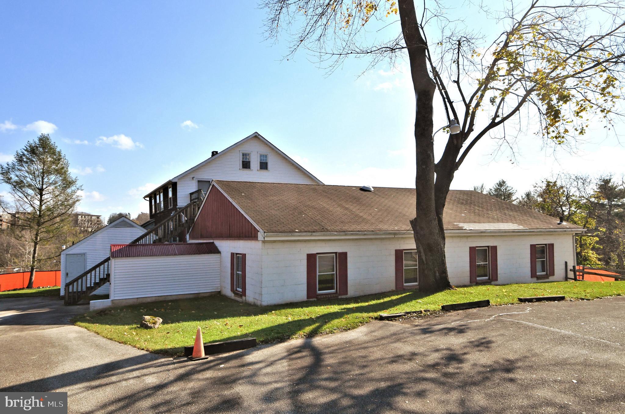 a view of a house with a yard and large tree