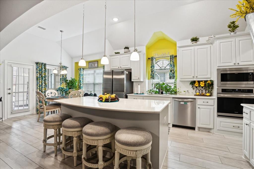 a kitchen with stainless steel appliances a dining table chairs and granite counter tops