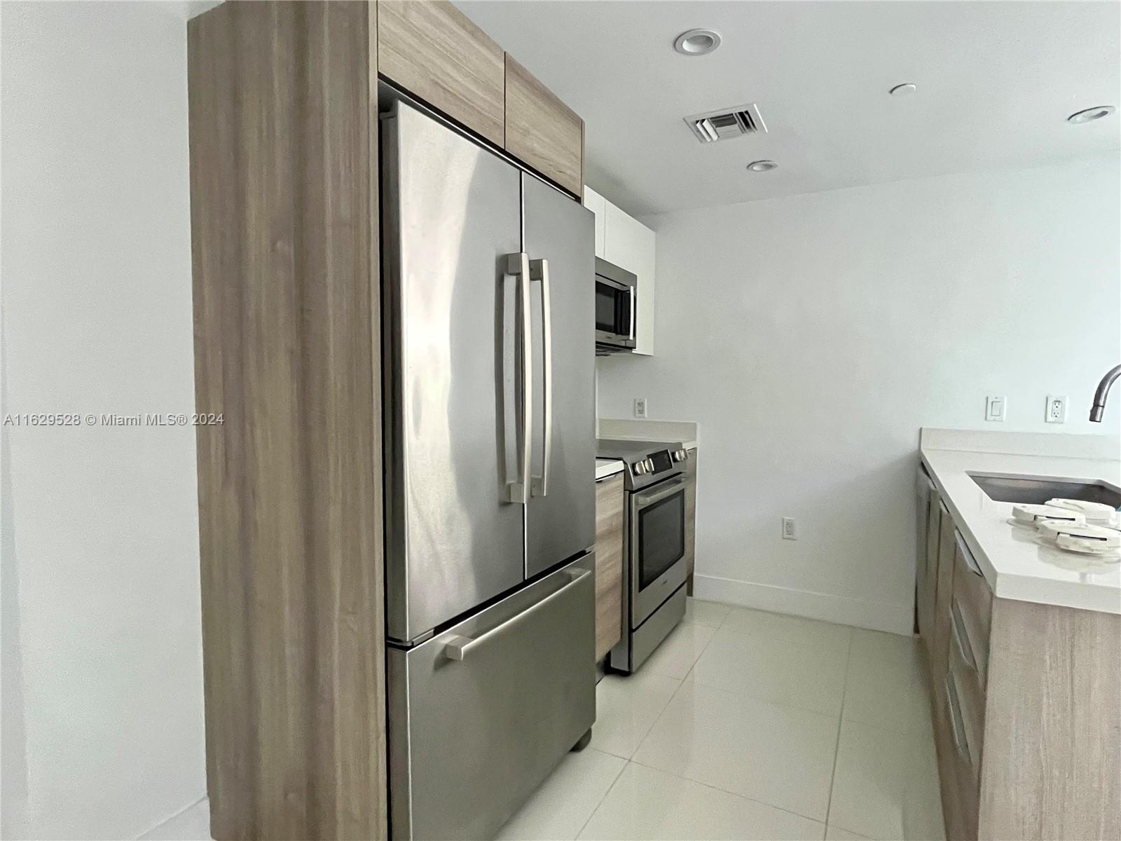 a kitchen with a refrigerator sink and stove