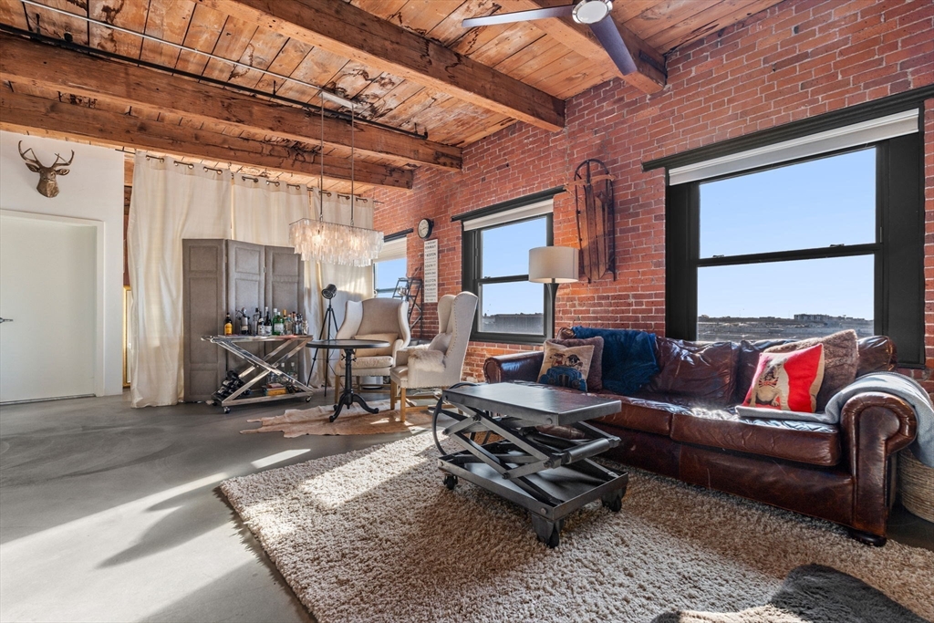 a living room with furniture a rug and a large window