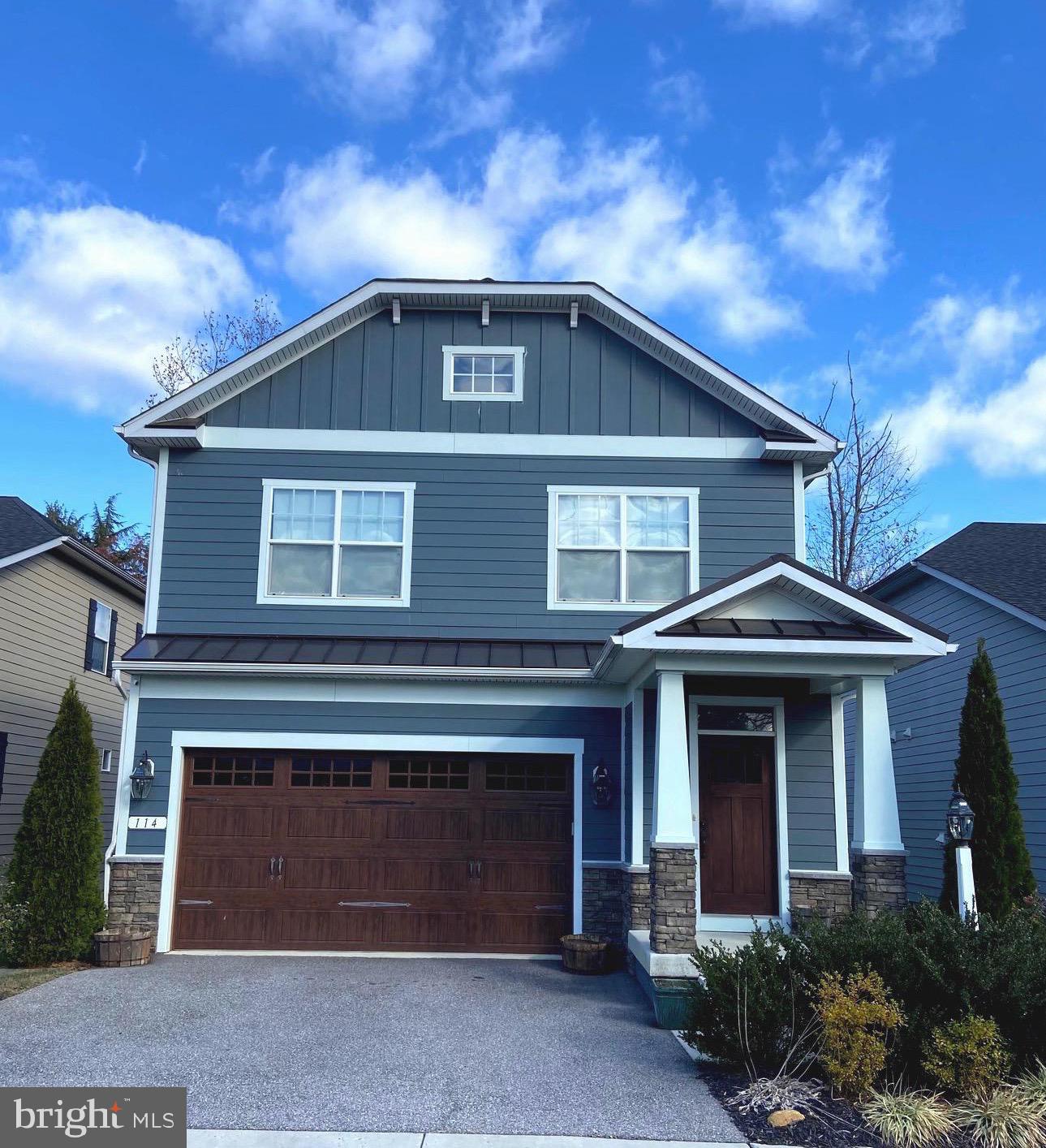 a front view of a house with a garden and yard