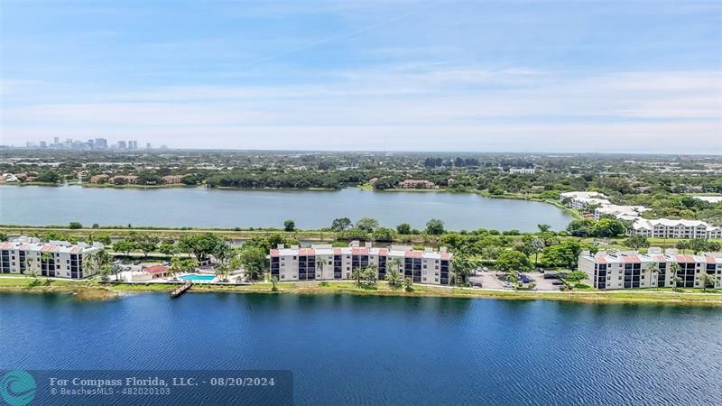 an aerial view of ocean and residential houses with outdoor space