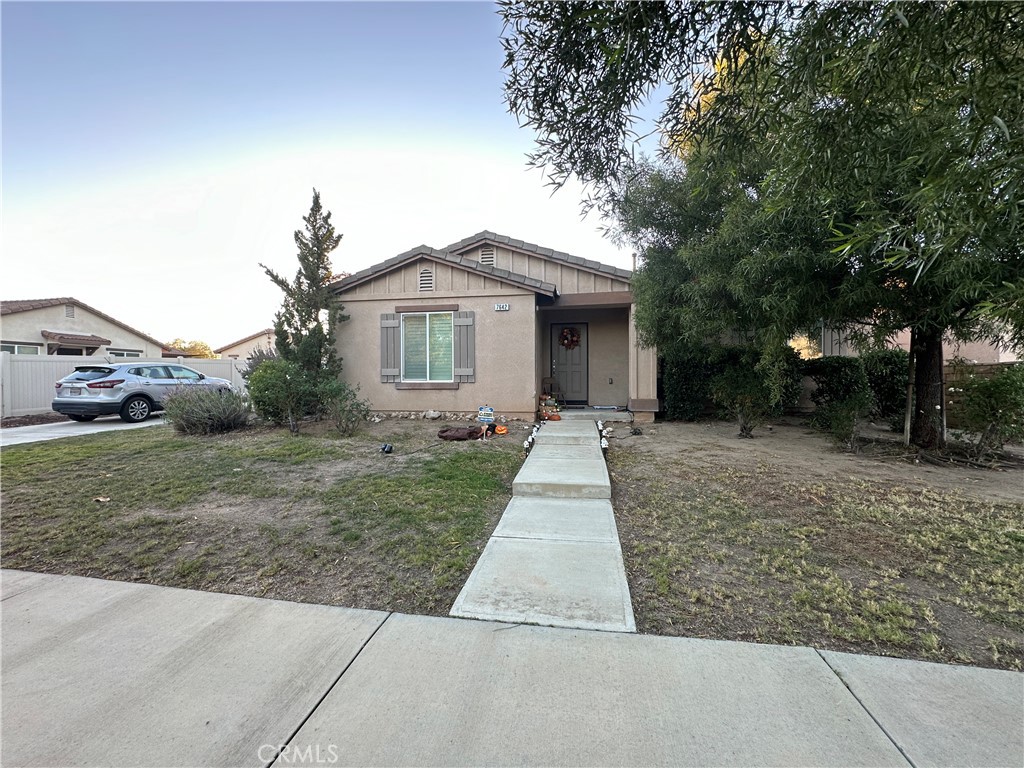 a front view of a house with a yard and trees