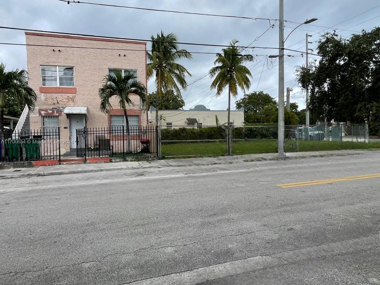 a palm tree sitting in front of a house with a big yard