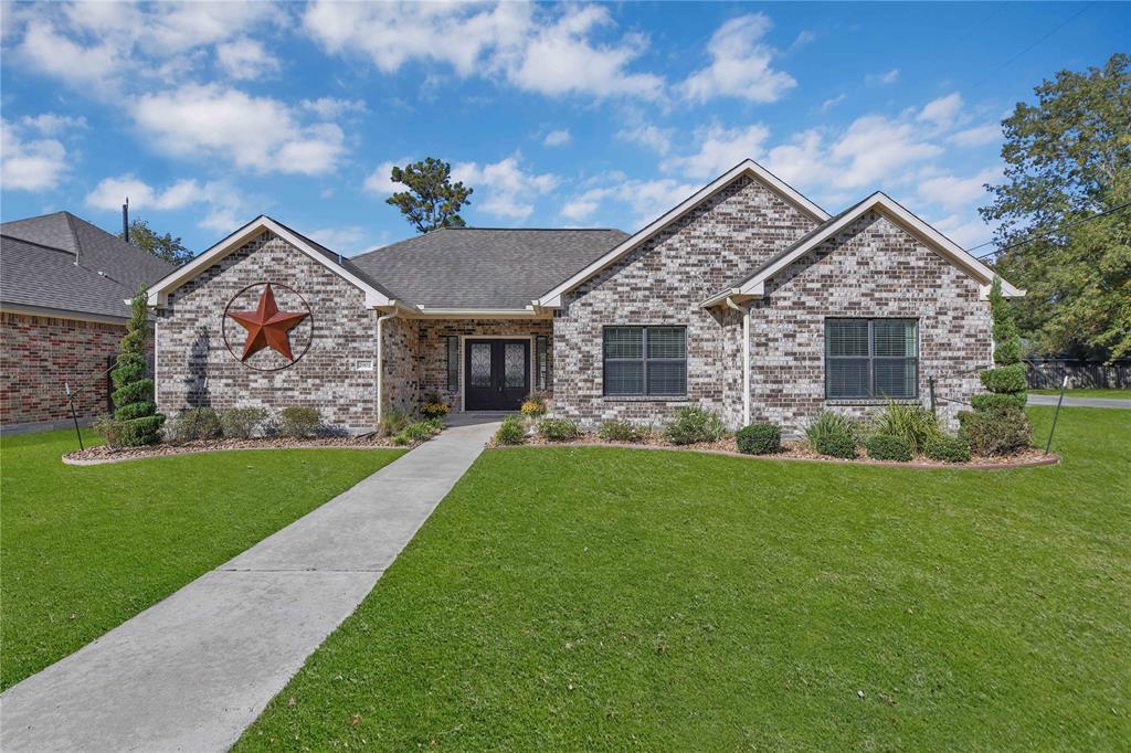 Charming single-story brick home with well-manicured lawn and inviting walkway, featuring a prominent star decoration on the facade and a cozy, welcoming entrance.