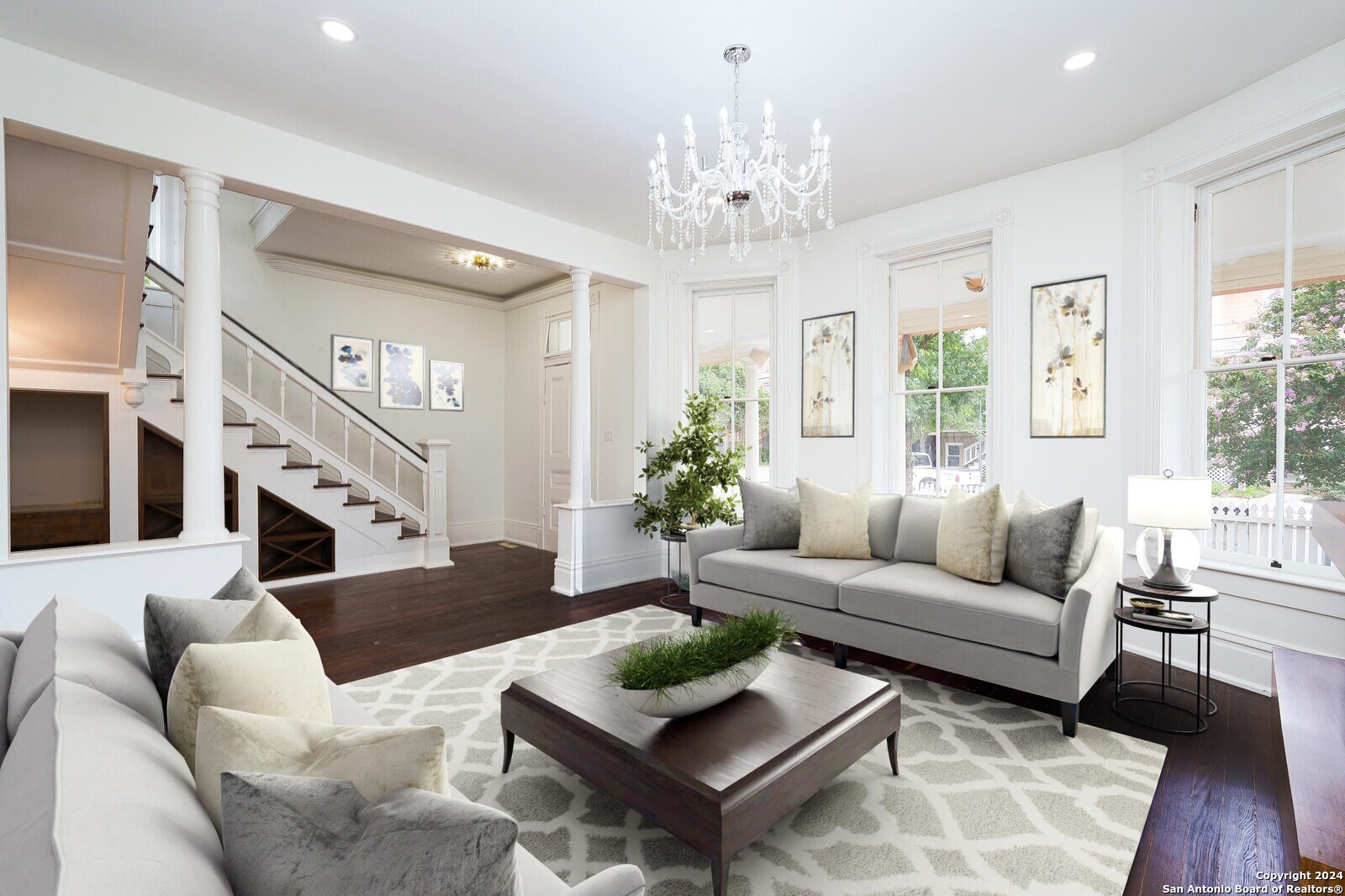 a living room with furniture or chandelier and a wooden floor