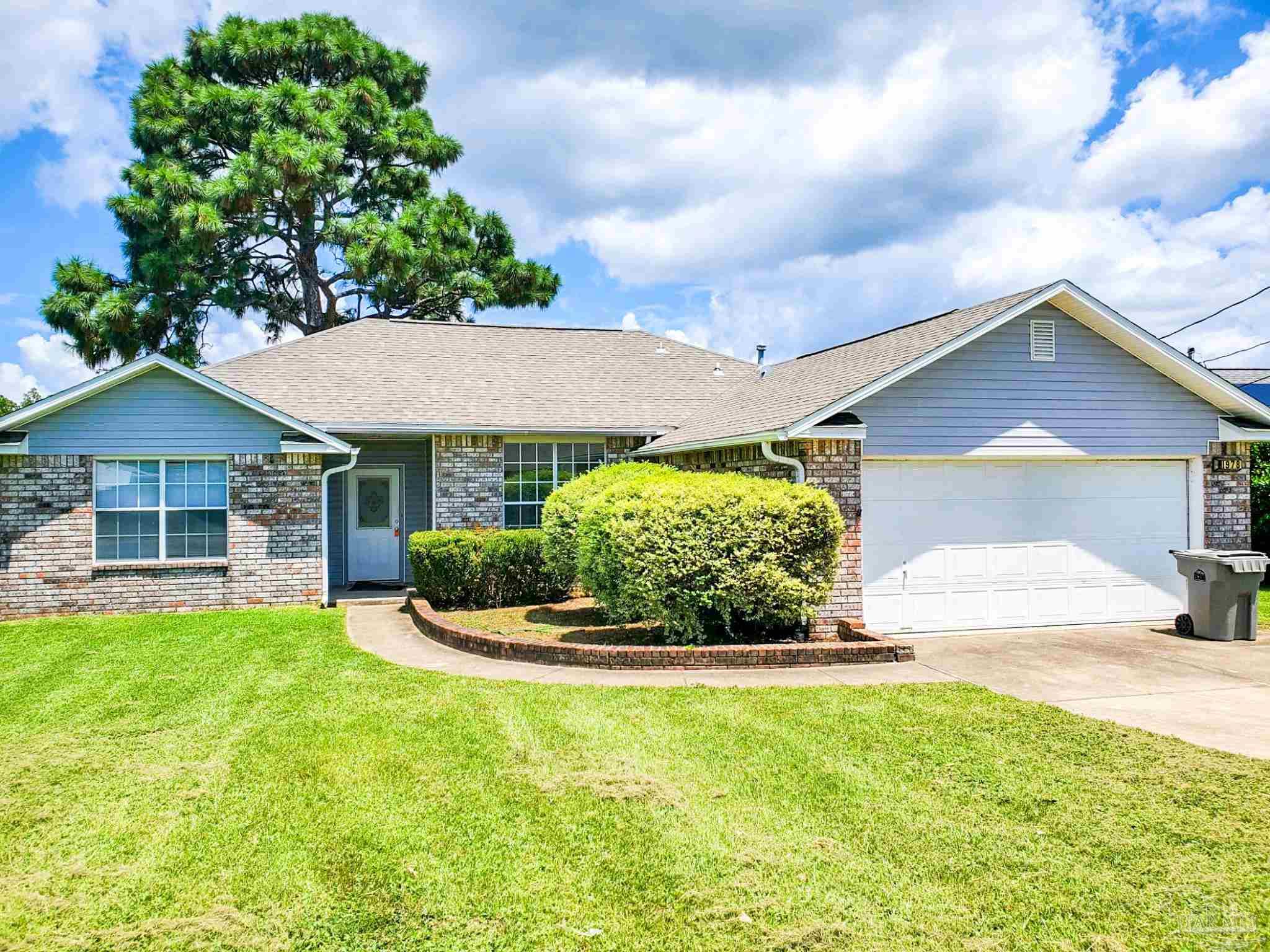 a front view of a house with a yard and garage