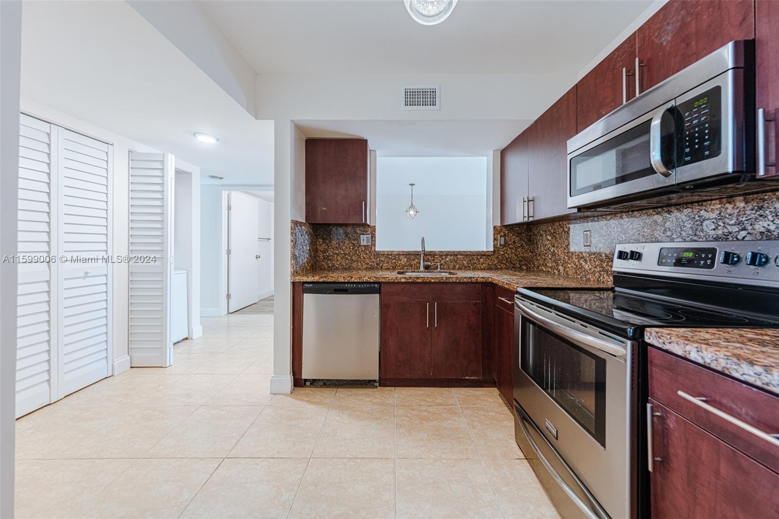 a kitchen with stainless steel appliances granite countertop a stove and a microwave