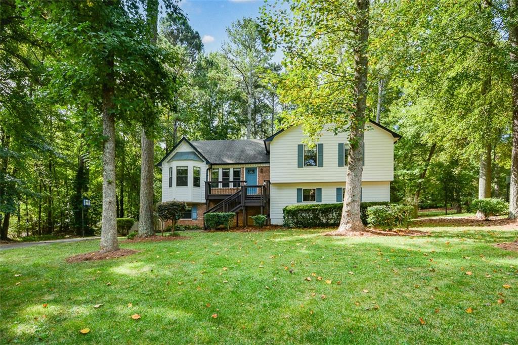 a front view of a house with a yard and trees