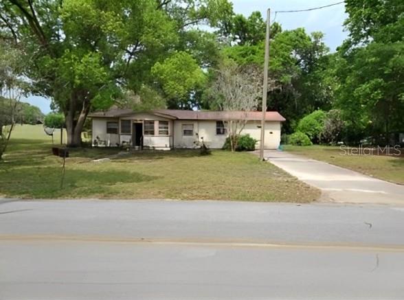 a front view of a house with a garden and trees