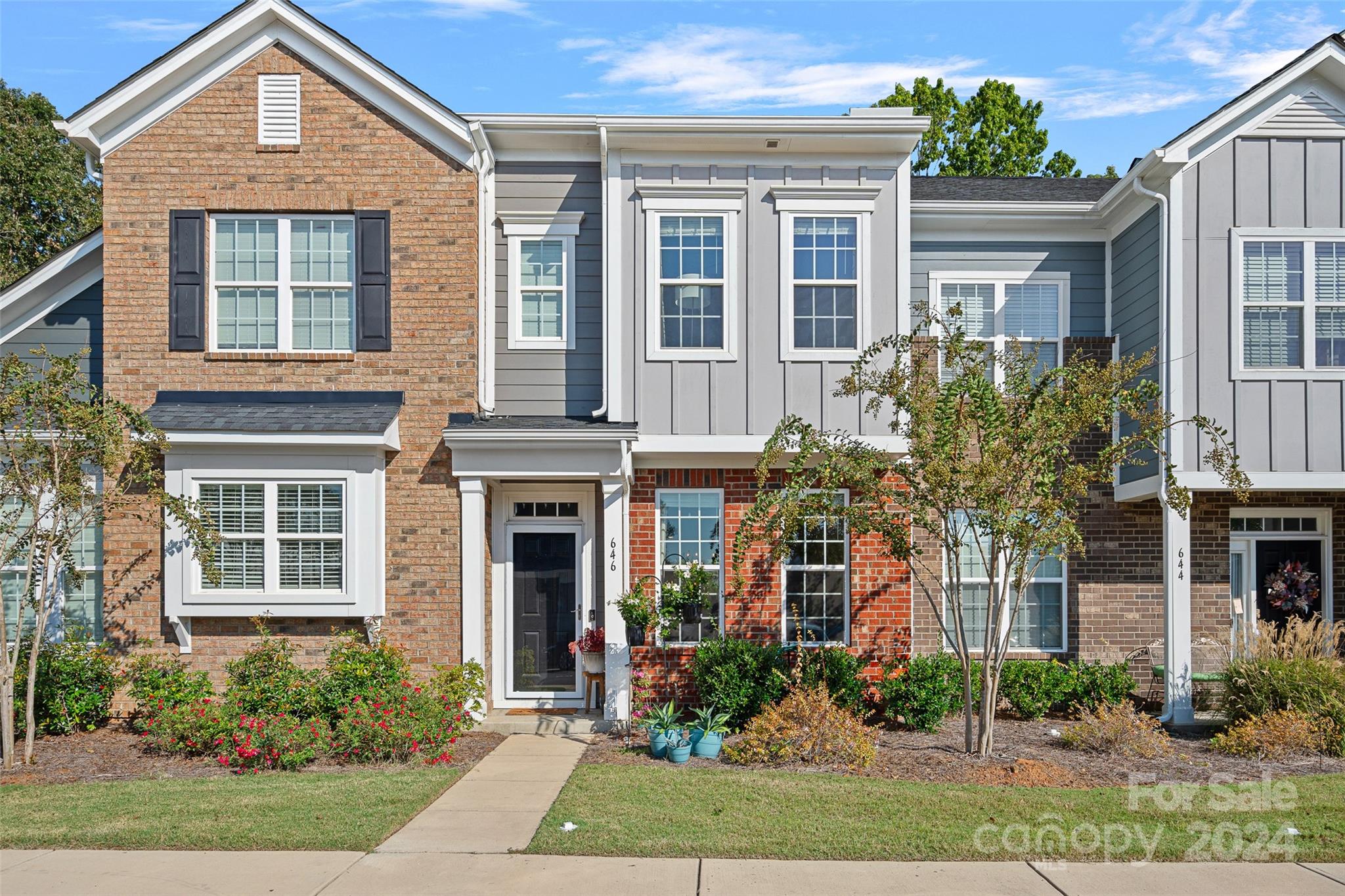 front view of a brick house with a yard