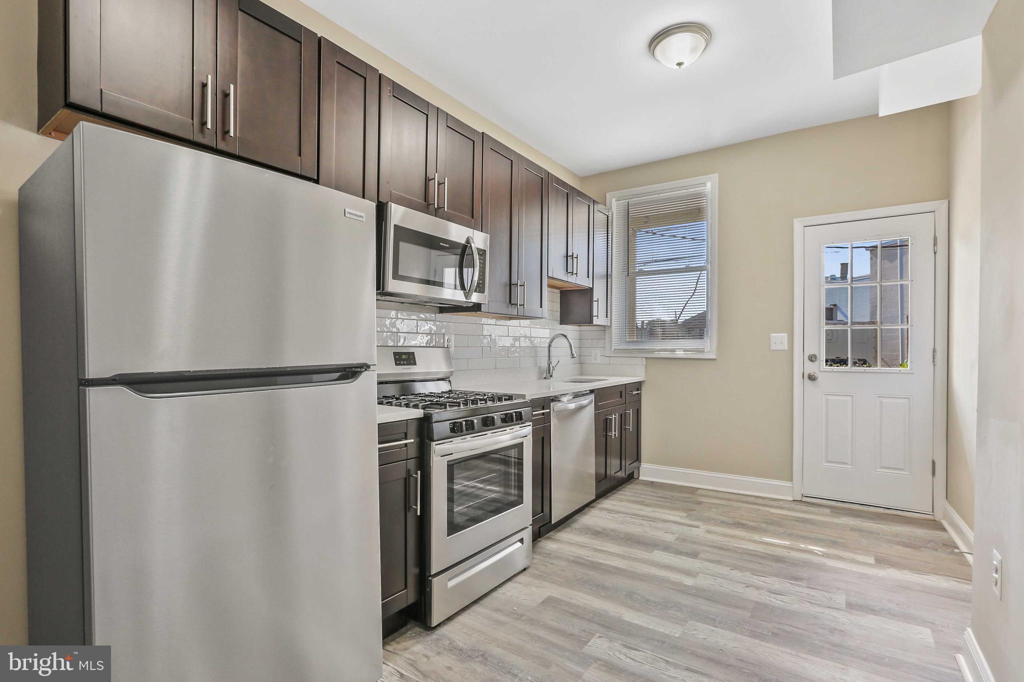 a kitchen with stainless steel appliances a refrigerator sink and cabinets