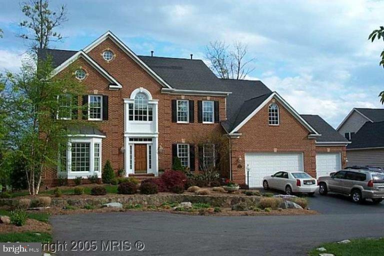 a front view of a house with cars parked