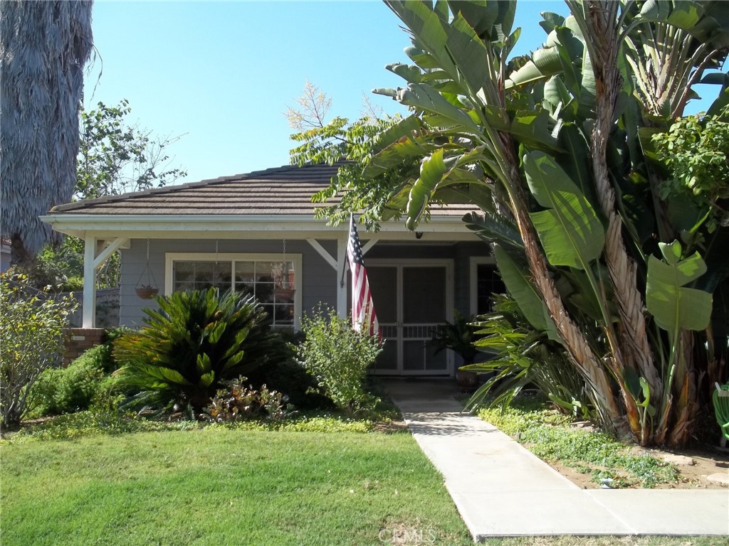 a view of house with a yard and potted plants