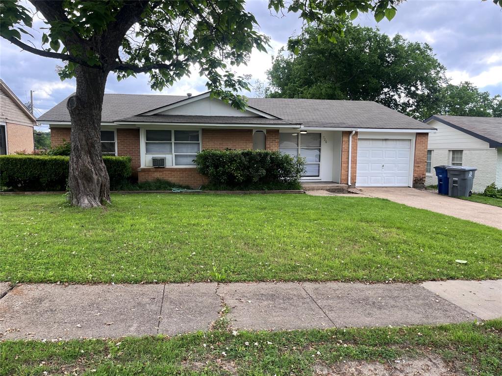 a front view of a house with a garden and yard