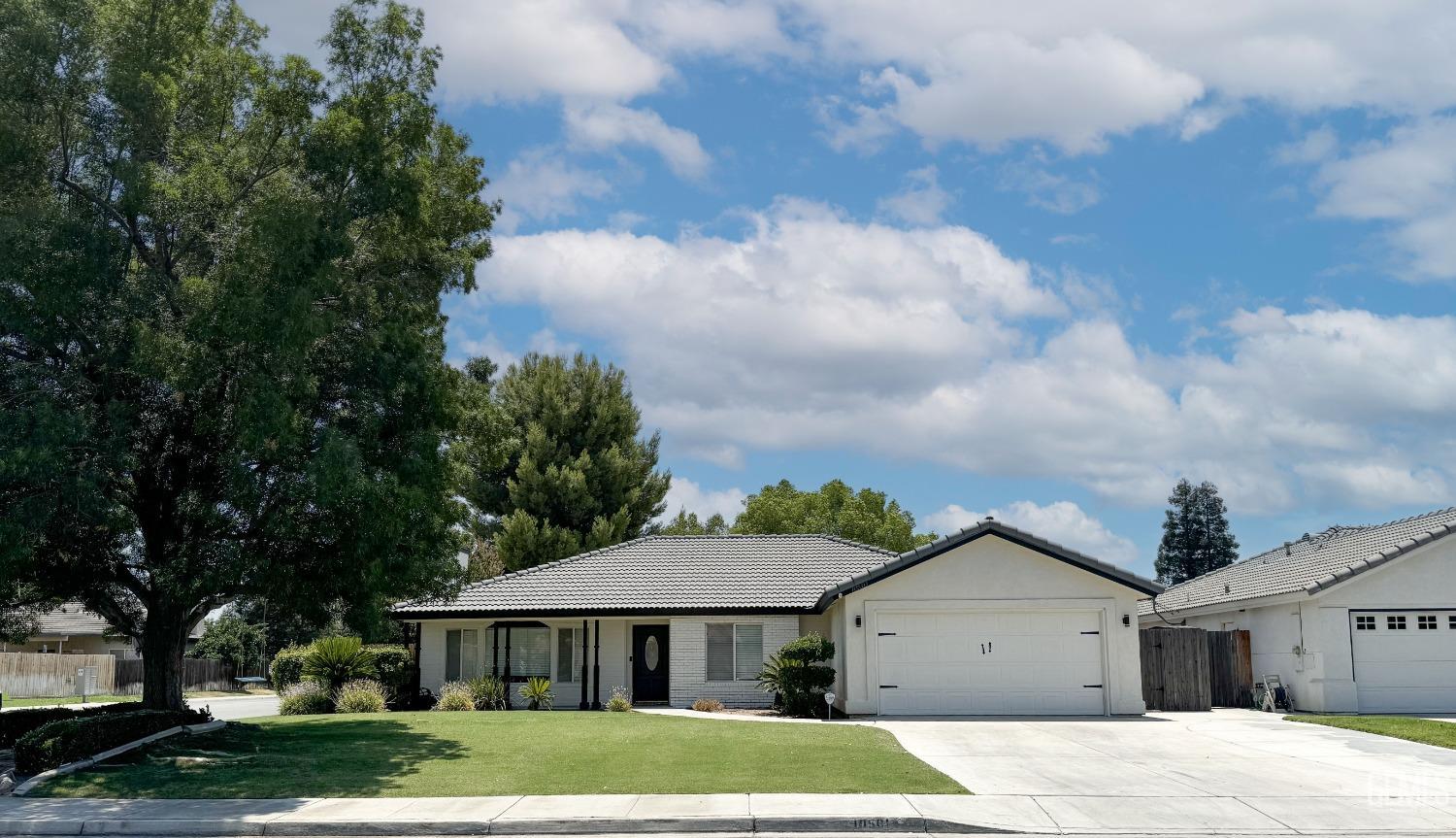 a front view of a house with a yard and trees