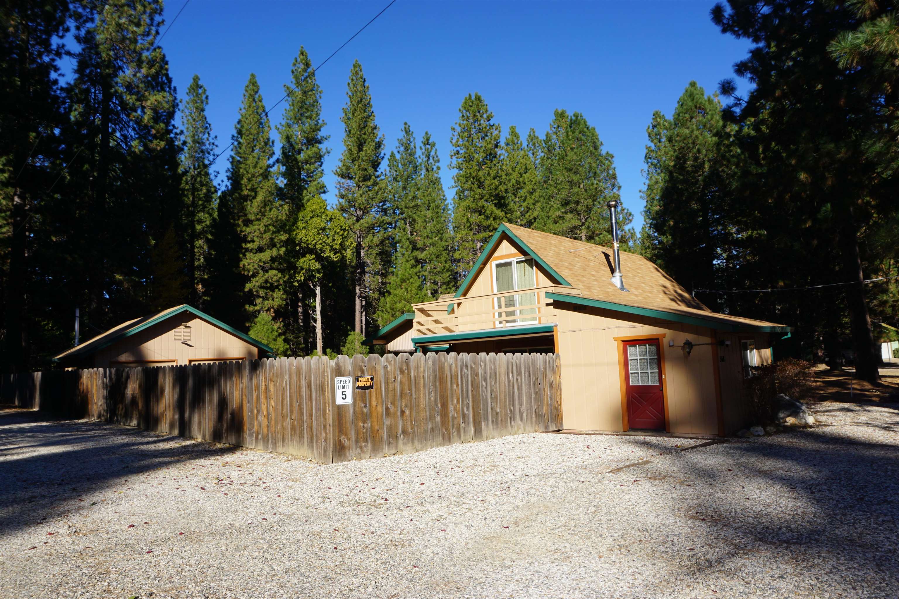 a view of a house with wooden fence next to a road