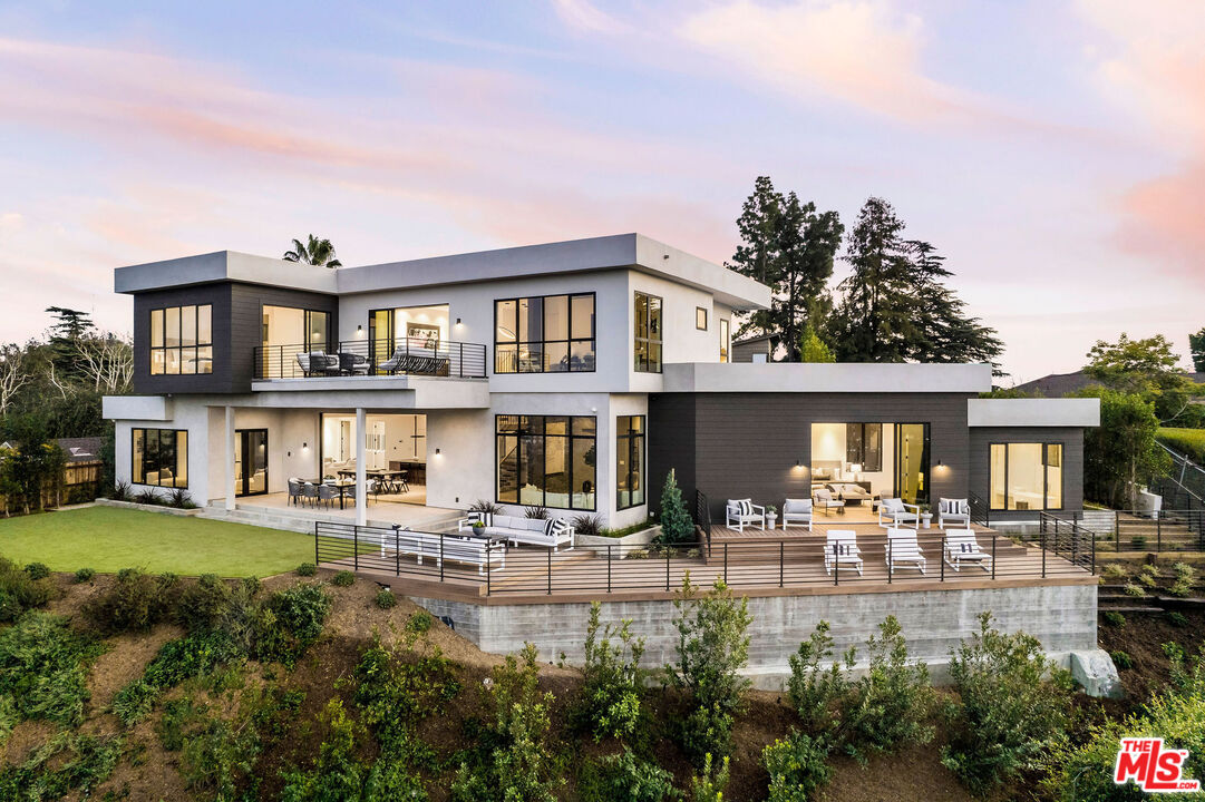 a front view of a house with swimming pool and outdoor seating