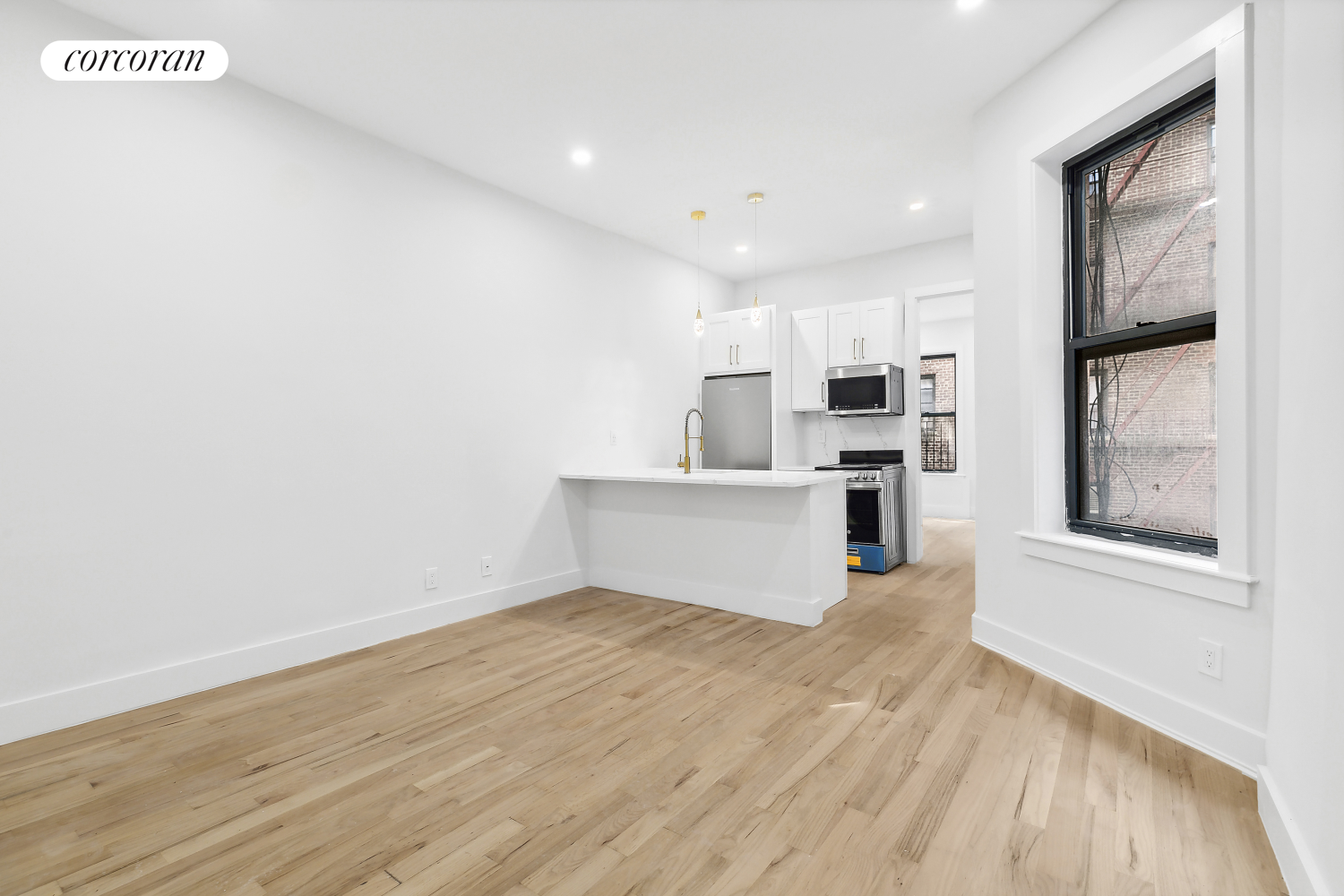 a view of a kitchen with wooden floor and electronic appliances