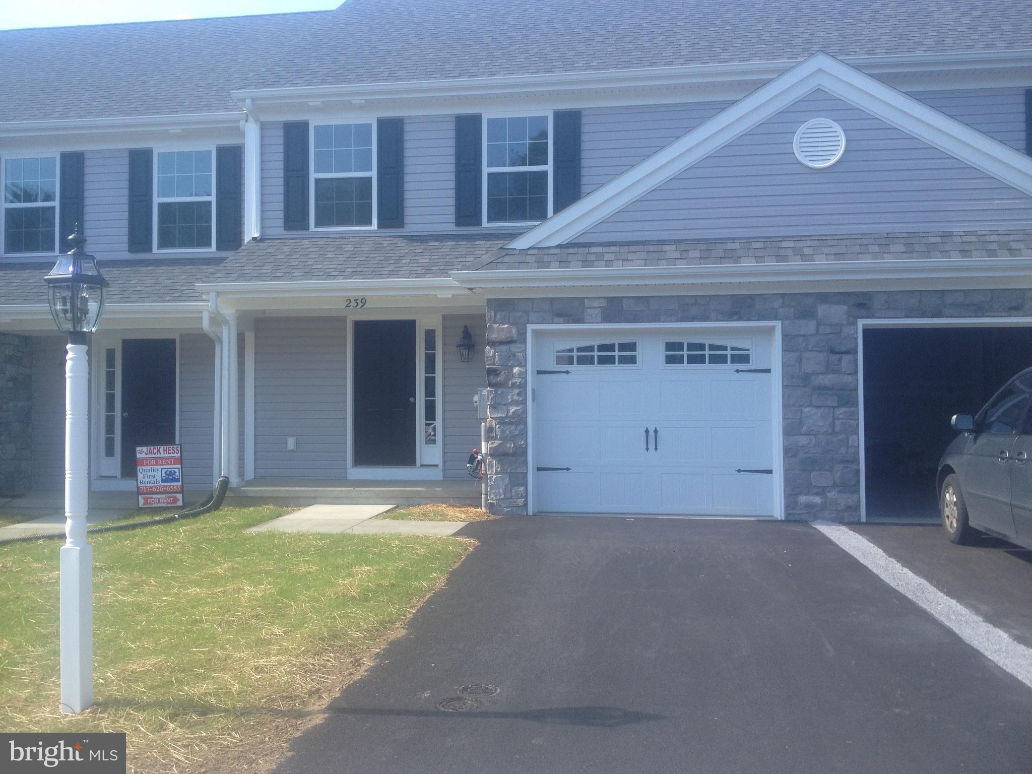 a view of a house with a patio and a yard