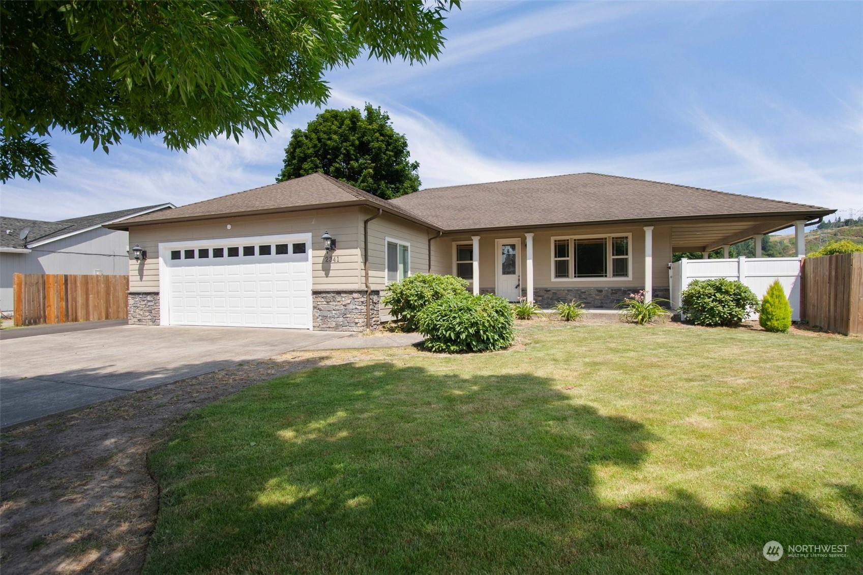 a view of a house with a yard and potted plants