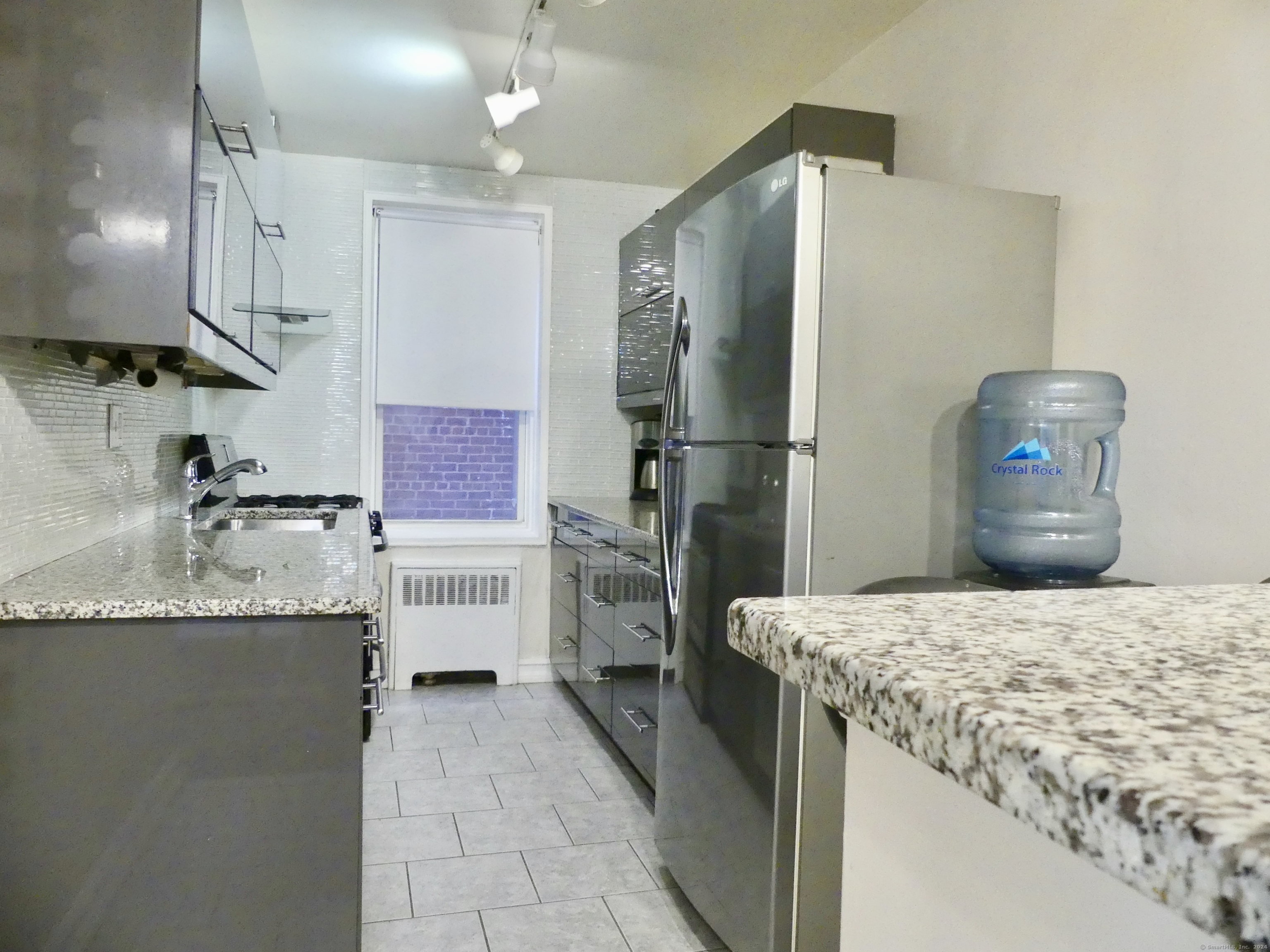 a kitchen with granite countertop a sink stainless steel appliances and cabinets