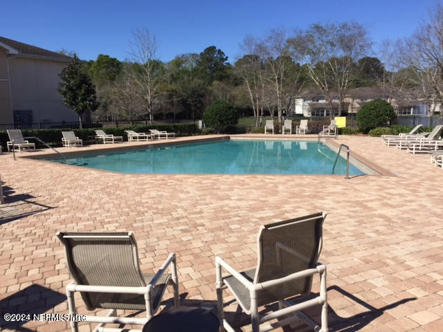 a view of a lake with a yard and a floor to ceiling window