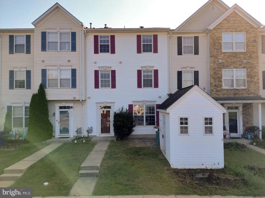 a view of house with yard and a garage